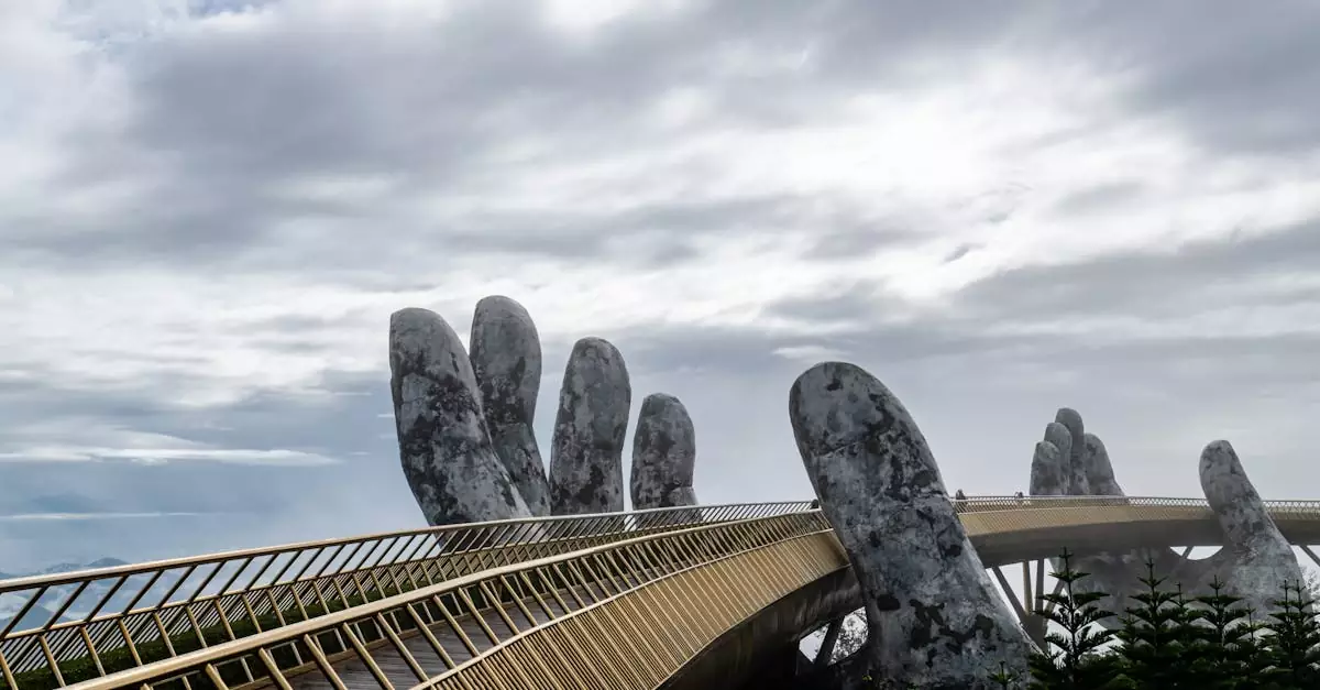 Photograph of the iconic Golden Bridge with hand sculptures in Da Nang, Vietnam under a cloudy sky.