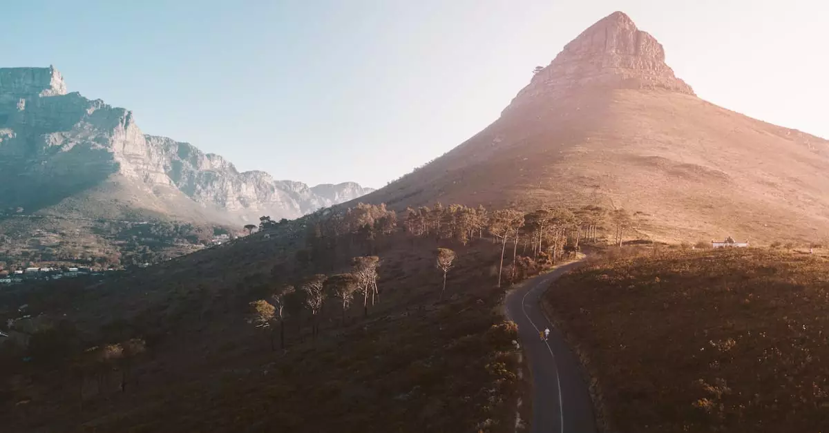 Stunning aerial view of Lion's Head in Cape Town at sunrise, showcasing the beautiful natural scenery and winding roads.