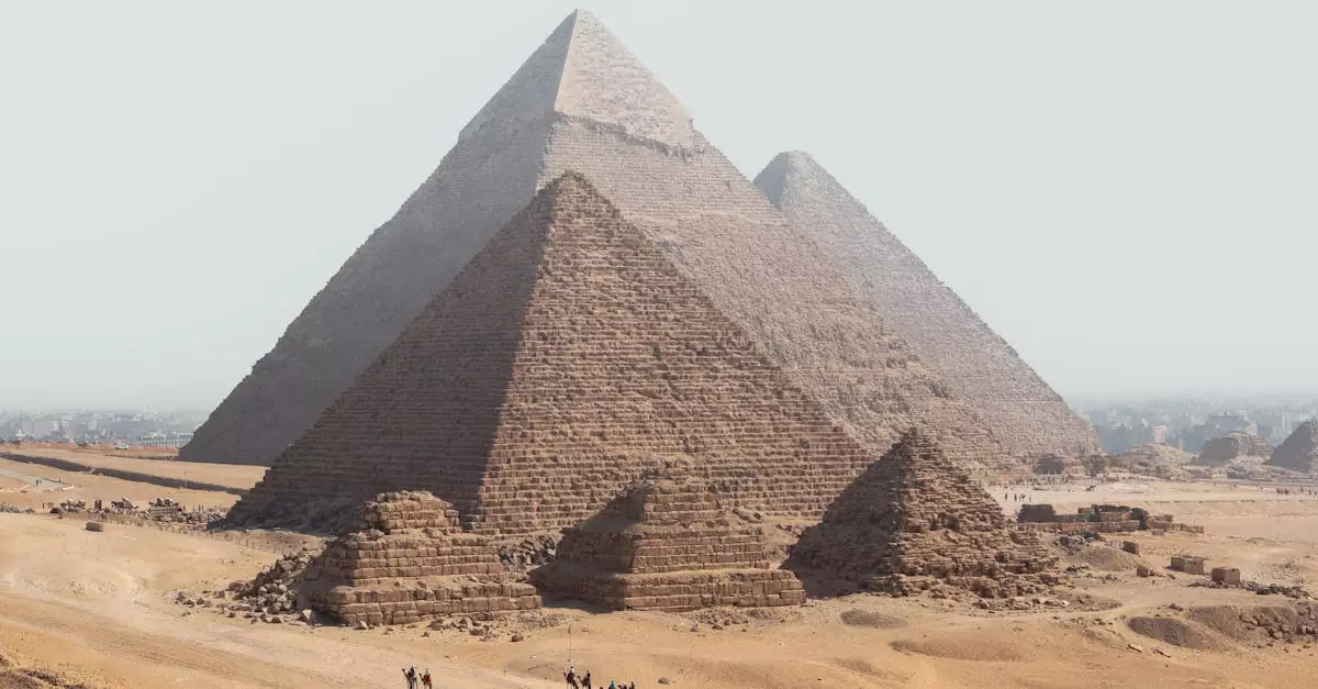 Panoramic view of the Giza Pyramids with camels in the desert under a clear sky.