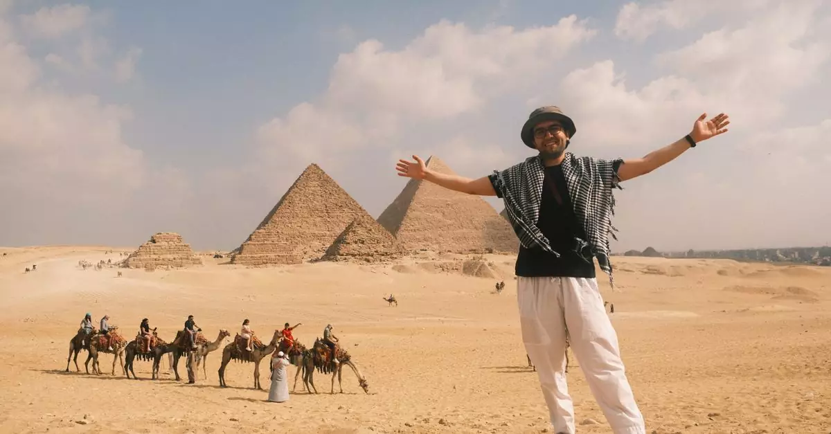 Smiling tourist with arms wide open in front of the majestic Pyramids of Giza with camels.