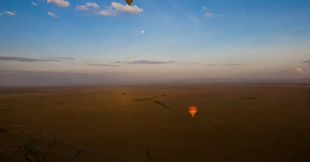 Stunning aerial view of hot air balloons soaring over Kenya's Maasai Mara at sunrise.