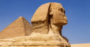 Majestic view of the Great Sphinx and Pyramid against a clear blue sky in Giza, Egypt.