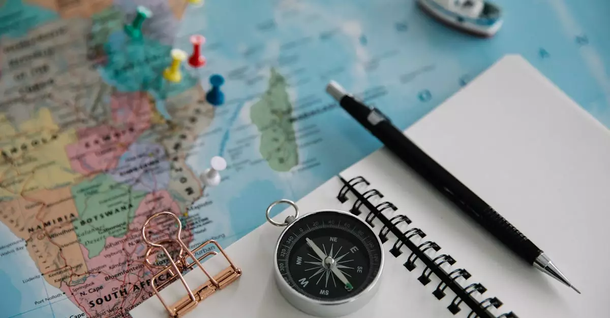 Flat lay of travel planning tools including a map, compass, notebook, and pen.