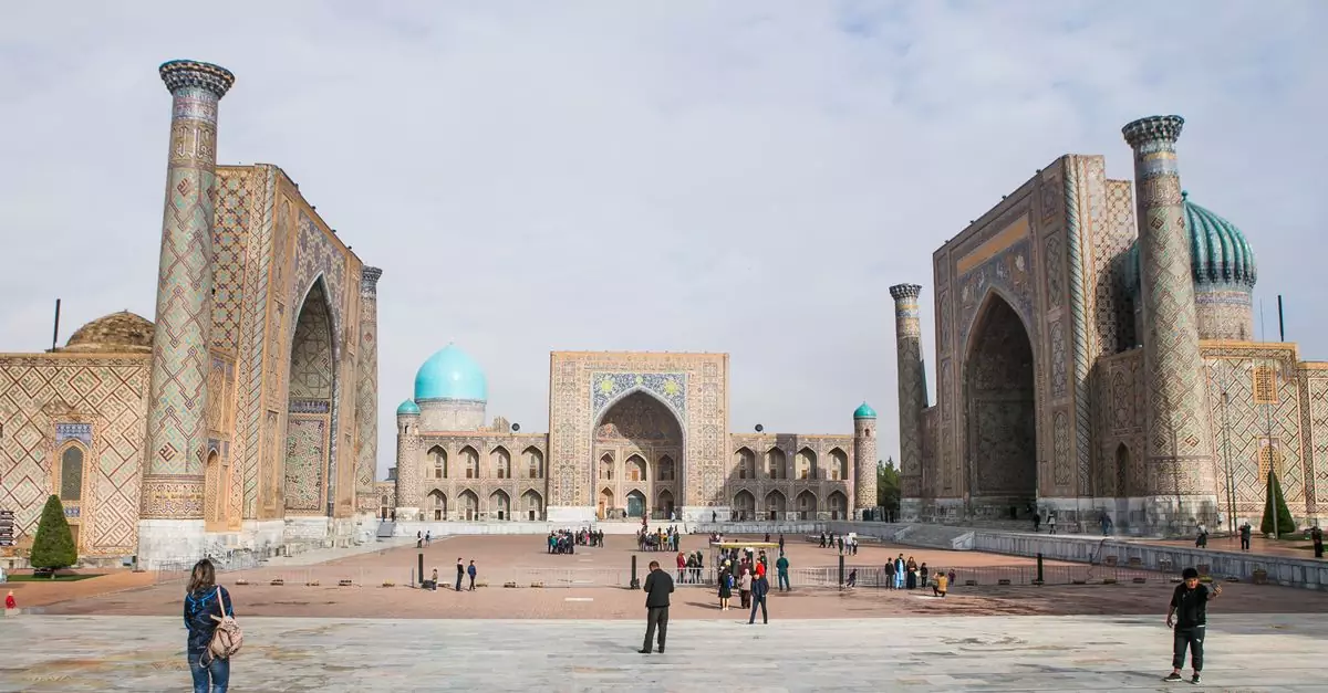 Historic Registan Square with tourists in Samarkand, showcasing stunning Islamic architecture.