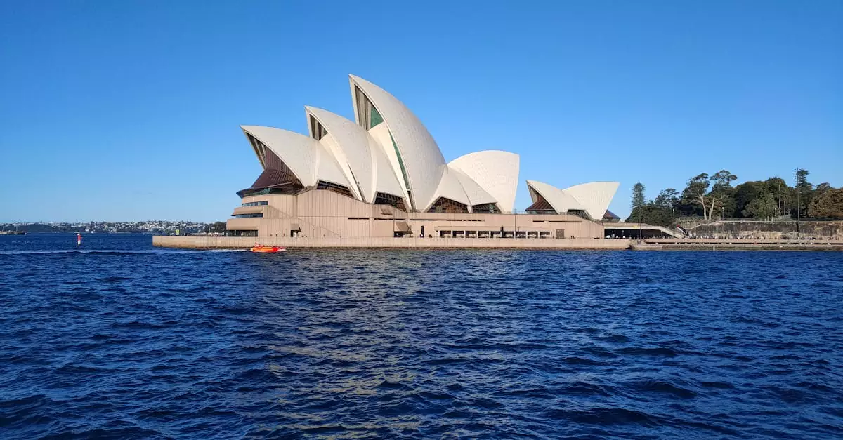 Stunning view of Sydney Opera House with vibrant blue sky and harbor waters.