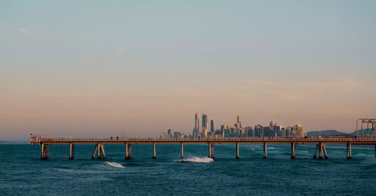Beautiful view of Sydney skyline with a pier extending over the ocean during sunset.