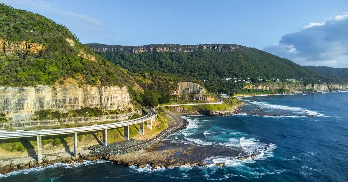 Stunning aerial shot of Sea Cliff Bridge along the Australian coastline under a clear blue sky.