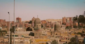 View of a cityscape blending ancient domed structures with modern buildings.