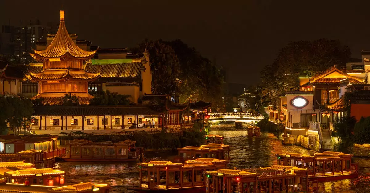 Discover the illuminated beauty of Nanjing's Qinhuai River at night, featuring traditional boats and a pagoda.