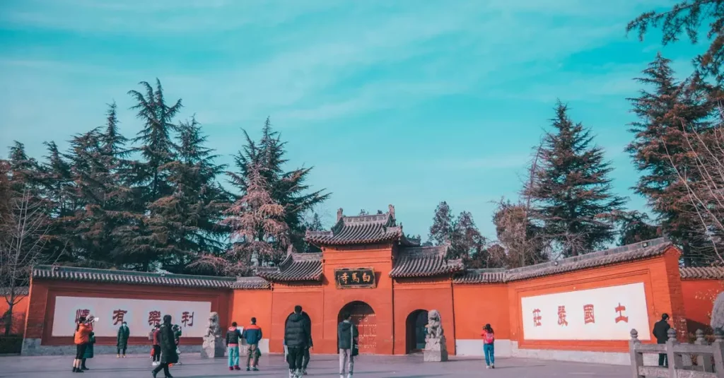 Best Cultural Experiences in China: Beyond the Great Wall 6 Tourists exploring an ancient Chinese temple entrance surrounded by lush trees.