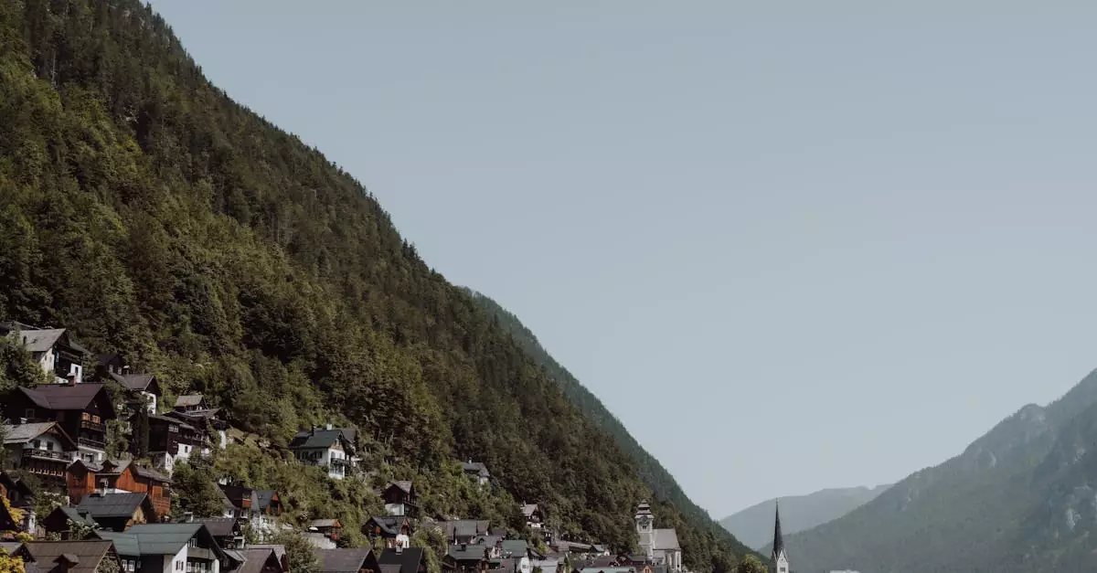 Picturesque view of Hallstatt village nestled by a serene lake surrounded by lush green mountains.