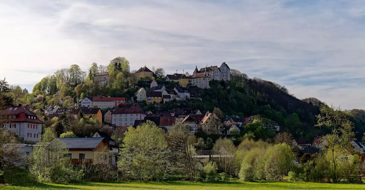 Picturesque hillside village of Egloffstein in Bavaria, Germany, surrounded by lush greenery.