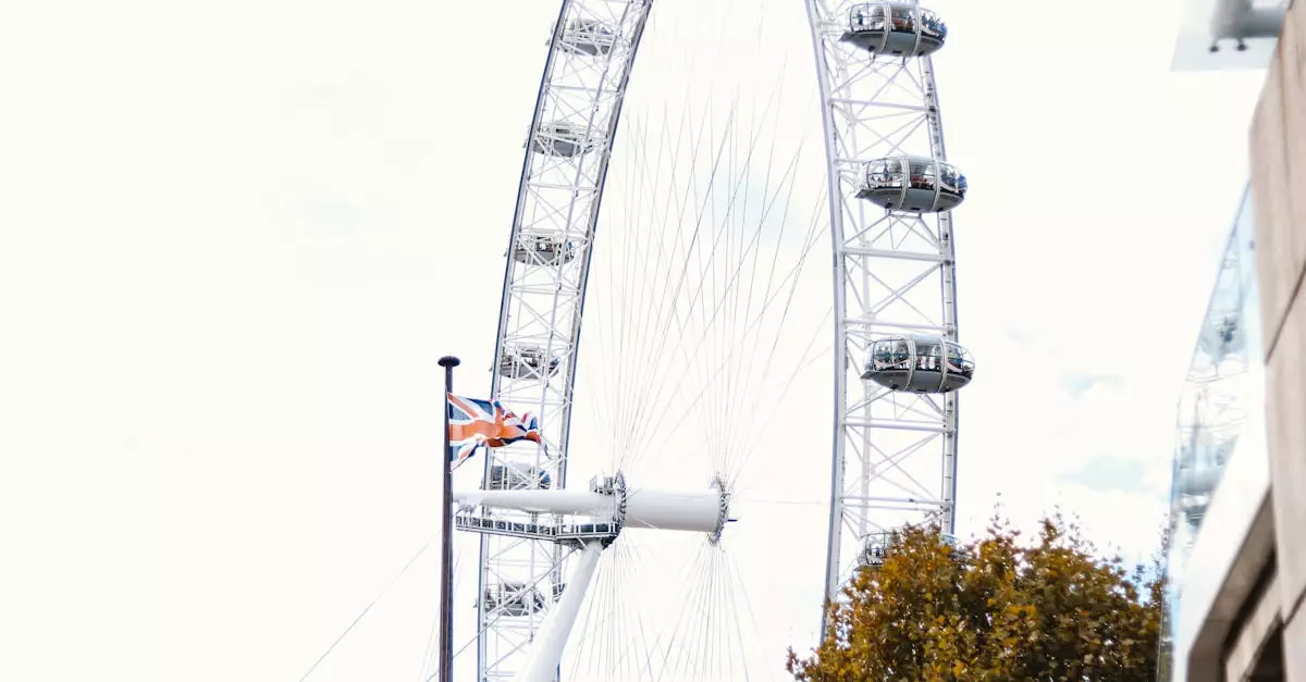 Low angle view of the iconic London Eye with autumn trees and Union Jack flag.