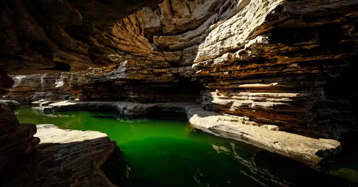 Stunning limestone cave showcasing dramatic rock formations and vibrant green water.