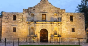Discover the iconic Alamo Mission's facade beautifully illuminated at dusk in San Antonio, Texas.