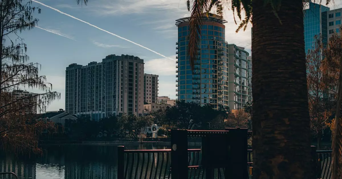 View of Orlando's modern skyline reflecting on a tranquil lake, surrounded by trees.