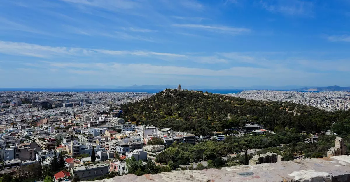 Panoramic view of Athens cityscape with iconic Lycabettus Hill, under clear blue skies.