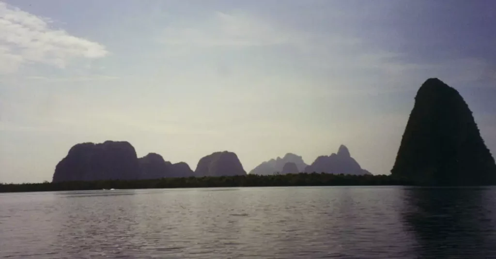 Peaceful view of Phang Nga Bay with limestone formations and calm sea in Thailand.