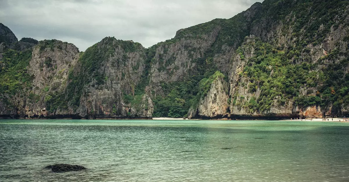 Tranquil Maya Bay in Thailand with lush limestone cliffs bordering crystal-clear waters.