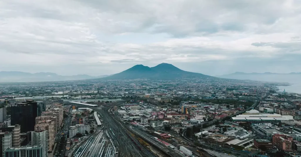 Breathtaking aerial cityscape of Naples overlooking Mount Vesuvius under a cloudy sky.