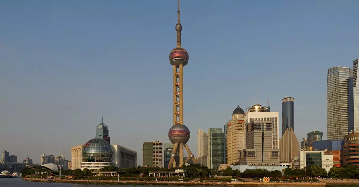 View of Shanghai skyline featuring the Oriental Pearl Tower and modern skyscrapers across the Huangpu River.
