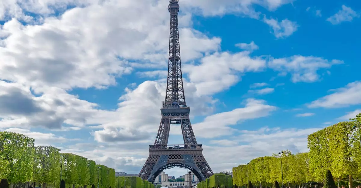 A scenic view of the Eiffel Tower with people enjoying the sunny day in Paris, France.