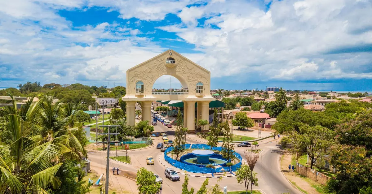 Scenic aerial view of Arch 22 in Banjul, The Gambia amid lush greenery and cloudy sky.
