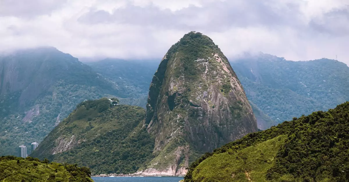 Breathtaking landscape of Sugarloaf Mountain shrouded in clouds, seen from Niterói, Brazil.