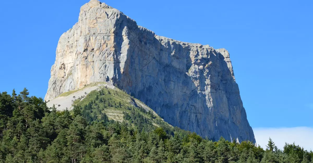 Explore the majestic Mont Aiguille in Chichilianne, France, surrounded by greenery and clear blue skies.