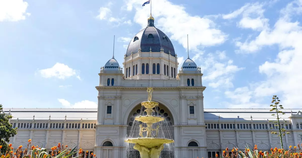 Exterior view of the Royal Exhibition Building in Melbourne with a clear blue sky and vibrant garden.