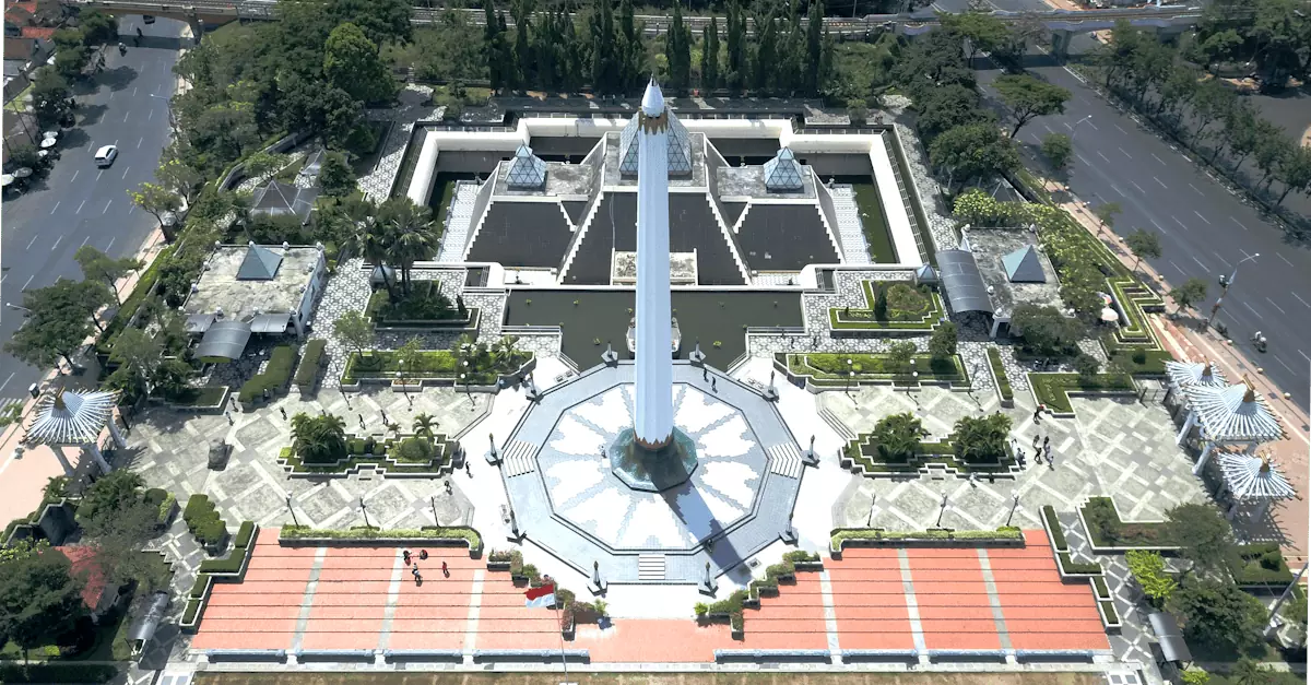 Aerial shot of Tugu Pahlawan, Surabaya's iconic monument surrounded by beautiful gardens.