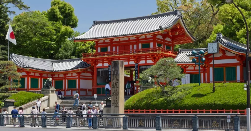 Best Places to Visit in Japan: 2026 Guide 2 Vibrant scene of Yasaka Shrine entrance in Kyoto, Japan during a sunny day, filled with visitors.