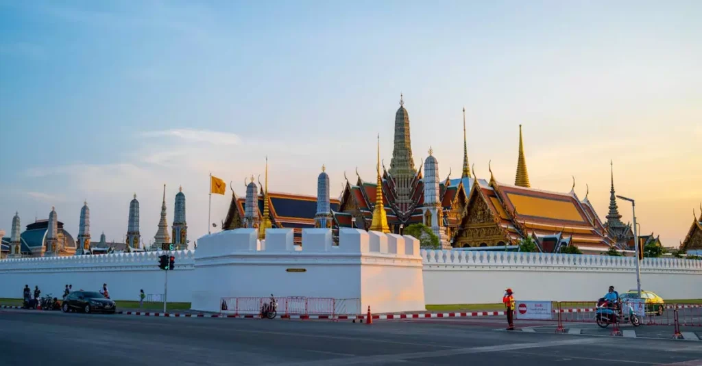 Stunning view of the Grand Palace in Bangkok with its traditional architecture during sunset.