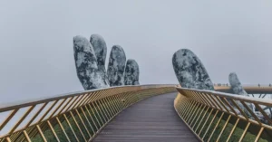 Golden Bridge with giant stone hands in mist, a landmark in Da Nang, Vietnam.