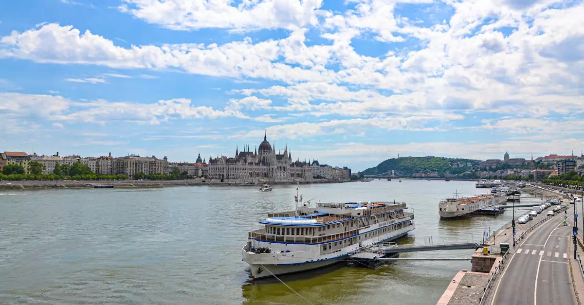 Panoramic view of the Budapest Parliament along the Danube River with cruise ships docked nearby.
