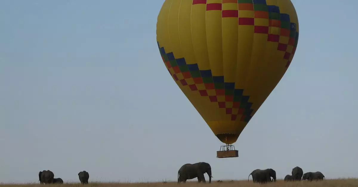 Hot air balloon floats above elephants on the African savannah, capturing adventure and wildlife.
