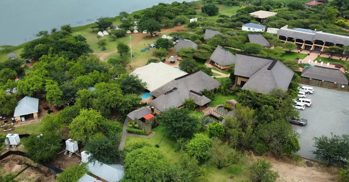 A beautiful aerial shot of a picturesque eco lodge surrounded by lush greenery and water.