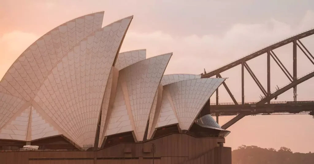 Best Scenic Australia Trips: Road Trips & Nature 7 Picturesque scenery of famous Sydney Opera House with modern expressionist design and arch bridge over harbor against amazing pink sunset sky
