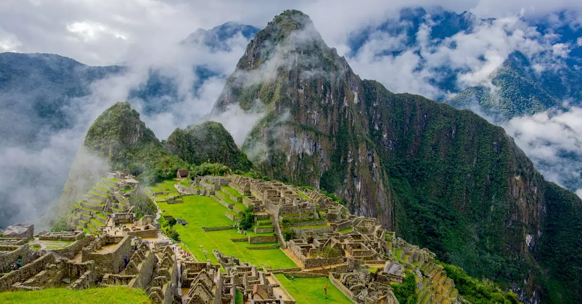 Stunning aerial view of Machu Picchu ruins surrounded by lush mountains and mist.