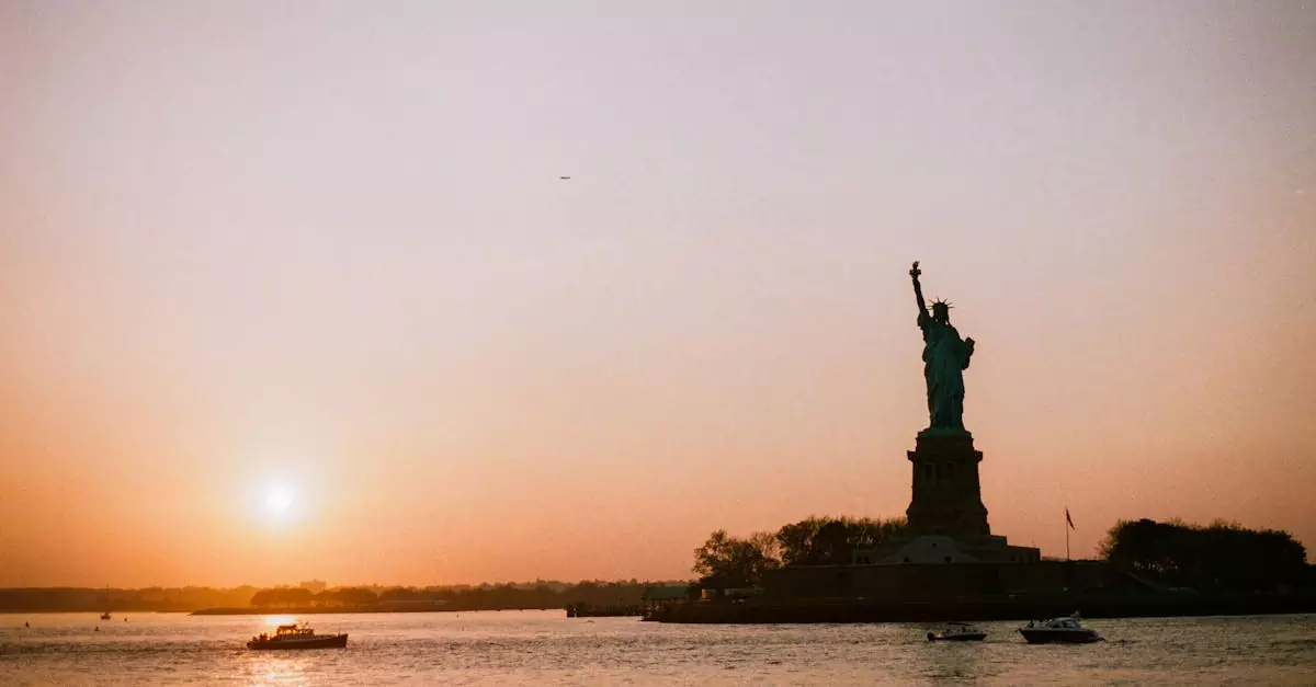 The Statue of Liberty silhouetted against a vibrant sunset on a tranquil evening.