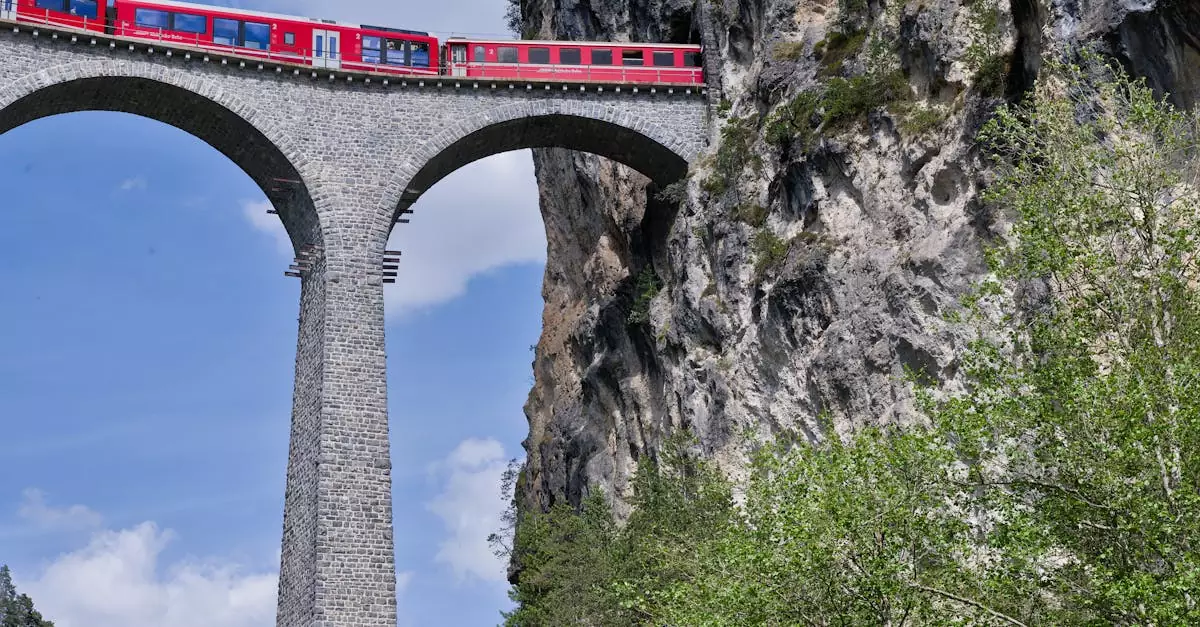 Stunning view of a red train crossing the Landwasser Viaduct in the Swiss Alps, framed by rocky cliffs.