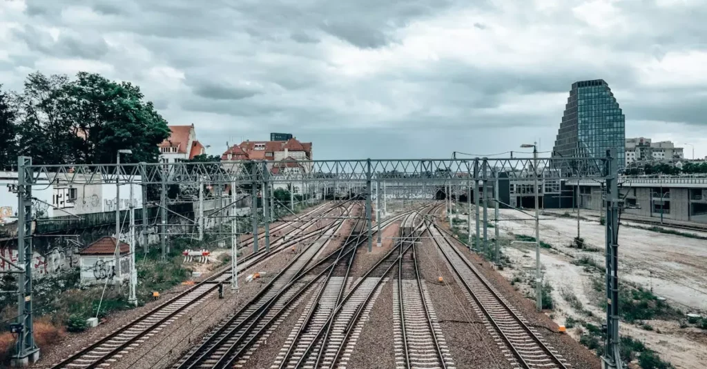 View of railway tracks and urban landscape in Poznań, Poland, under a cloudy sky.