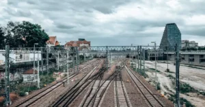 View of railway tracks and urban landscape in Poznań, Poland, under a cloudy sky.