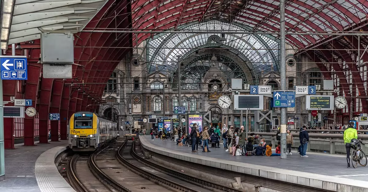 Bustling European train station with commuters and approaching train. Captivating architectural details.