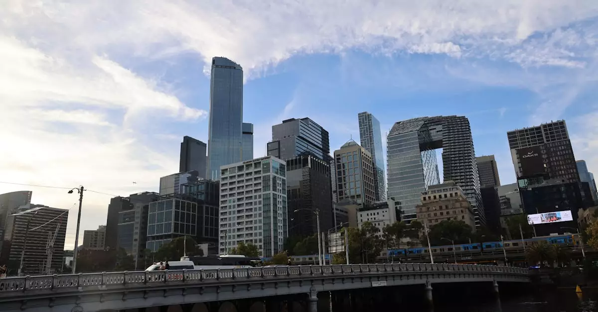 View of the Melbourne skyline with modern skyscrapers and a bridge during the day.