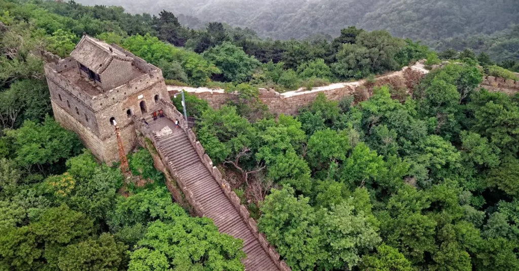 Best UNESCO Sites China: History, Culture & Nature 8 Drone shot of the Great Wall of China amidst lush greenery in Huairou, Beijing.