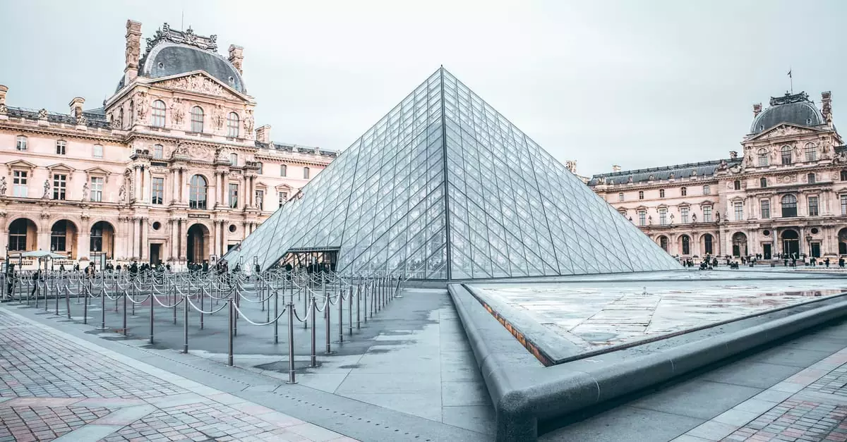Iconic Louvre Pyramid in Paris, showcasing classic and modern architecture.