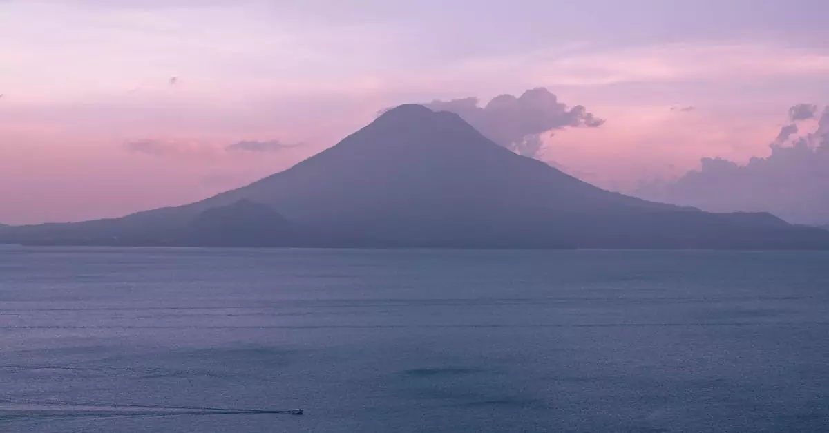 A breathtaking view of a sunset over Lake Atitlán in Guatemala with a volcano silhouette.