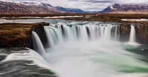 Capture the awe of Godafoss waterfall in Iceland's stunning landscape, a favorite travel destination.