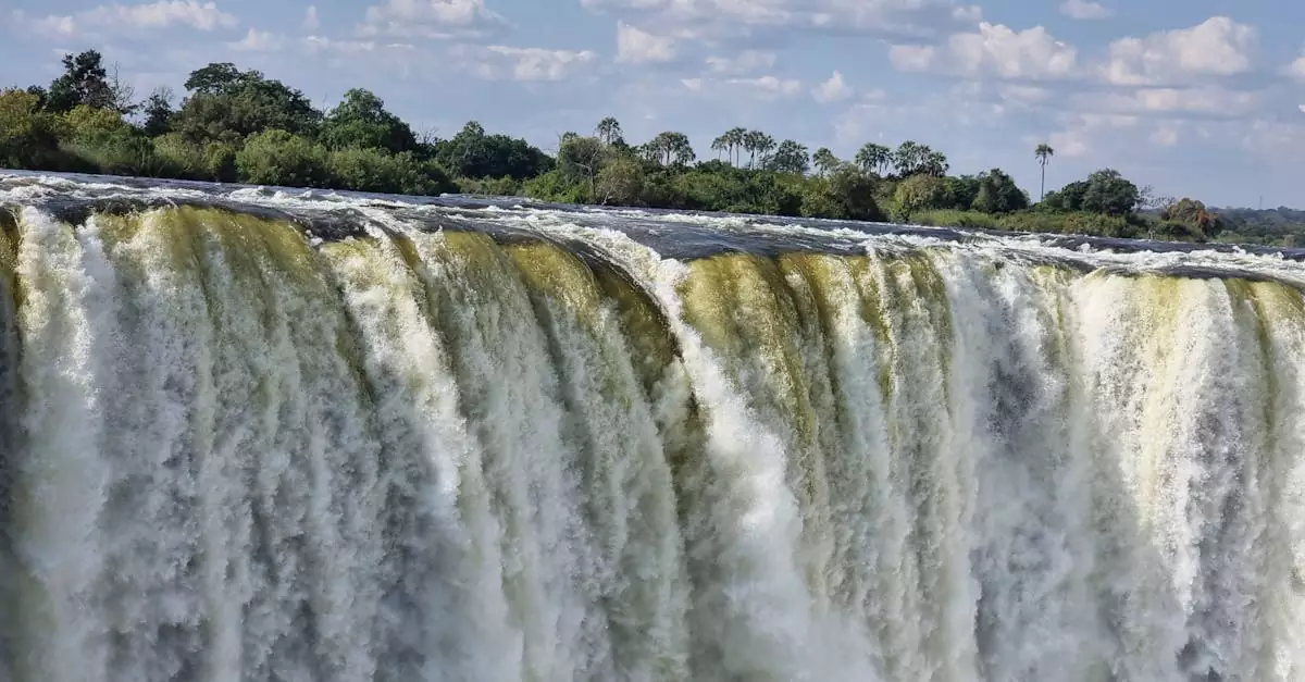 Stunning view of Victoria Falls cascading with vibrant energy, surrounded by lush greenery.